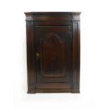 A mid 18th century oak wall hanging corner cupboard,