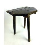 An 18th century oak and pine primitive cricket table, with the top cut down on three chamfered legs,