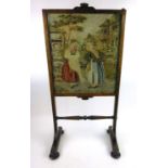 A Victorian simulated rosewood fire screen with embroidered panel behind glass. h. 110 cm, w.