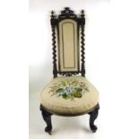 A Victorian walnut nursing chair with florally embroidered upholstery,