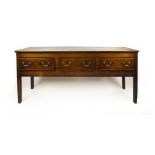 An 18th century and later oak dresser base the top over three drawers with brass swan neck handles