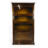 An early 20th century walnut four section glazed bookcase by Gunn furniture Co.