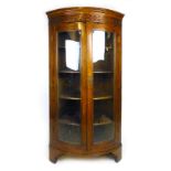 A 19th century oak and rosewood crossbanded bow fronted floor standing corner cupboard,