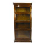 An early 20th century walnut four section glazed bookcase by Gunn furniture Co.