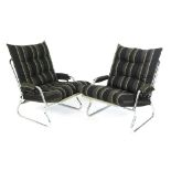 A pair of chromed tubular lounge armchairs with loose cushions