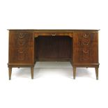 A 1950/60's walnut bow fronted desk with an arrangement of eight drawers and a slide on tapering