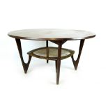 A 1960's teak circular coffee table with a second wickerwork tier on triangular form legs by Kurt