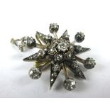 A yellow metal and white metal highlighted pendant/brooch in the form of a snowflake set brilliant