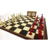 A late 19th century Chinese chess set, with turned ivory and bone pieces with carvings,