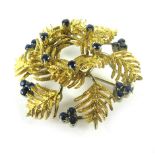 An 18ct yellow gold brooch of wreath design set small sapphires, d. 3.5 cm, 12.