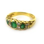 An 18ct yellow gold ring set three graduated oval emeralds and eight small diamonds, ring size P, 4.