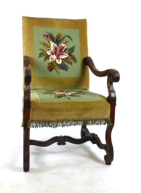 A Victorian walnut Italian style open arm chair with floral needle work upholstery and acanthus