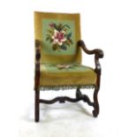 A Victorian walnut Italian style open arm chair with floral needle work upholstery and acanthus