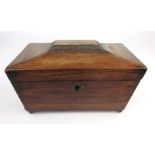 A Regency sarcophagus shaped rosewood tea caddy with two internal tea compartments on brass ball