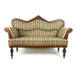 A 19th century walnut two seat sofa upholstered in striped silk fabric with shaped and carved top