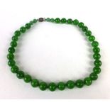 A single strand graduated green jade bead necklace, overall l.