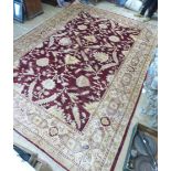 A hand woven Persian rug, the double lined border enclosing a foliate design red ground field.