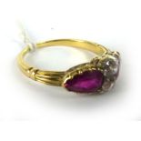 A yellow metal ring set centrally with two old cut diamonds and two pear shaped rubies within