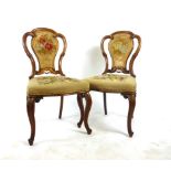 A pair of Victorian walnut bedroom chairs with floral needle work upholstery and serpentine shaped