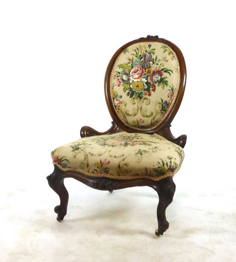 A Victorian walnut balloon back bedroom chair upholstered in floral print fabric on carved cabriole