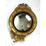 A Regency gilt framed convex mirror with applied balls to frame and carved eagle to top. h.