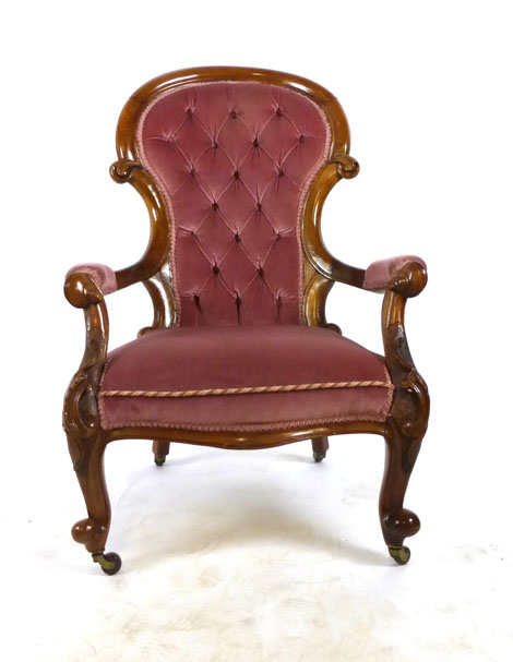 A Victorian walnut salon chair upholstered in a cut pink button backed fabric on carved cabriole