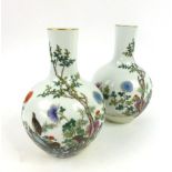 A pair of early 20th century Japanese bottle vases decorated in enamels with birds and trees, h. 23.