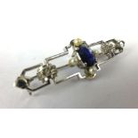 A 9ct white gold bar brooch set oval sapphires,