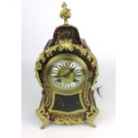 A French boule and gilt brass mounted mantle clock with torch finial above the face with enameled