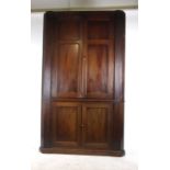 A William IV mahogany floor standing barrel backed cupboard with two panelled cupboard doors