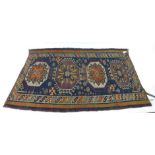 A handwoven Caucasian kilim, the border enclosing a blue ground field with four octagons,