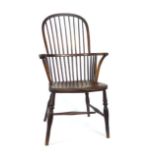 A 19th century oak and elm comb back Windsor arm chair on turned legs and stretchers. h. 112 cm, w.