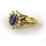 An 18ct yellow gold cluster ring set oval sapphire and twelve diamonds within a fleur de lis mount,