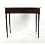 A Regency mahogany writing table, the bow fronted top over two drawers on turned legs. h. 71 cm, w.