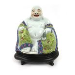 A Chinese figure modelled as a seated Buddha decorated in yellow and blue enamels,