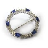 An 18ct white gold circular brooch of openwork form set six rectangular cut sapphires interspersed