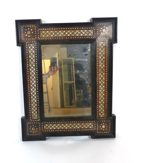 A 19th century Indian mirror with ebonised moulded, walnut and ivory inlaid frame. h. 53 cm, w.