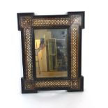 A 19th century Indian mirror with ebonised moulded, walnut and ivory inlaid frame. h. 53 cm, w.