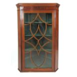 An early 19th century mahogany and boxwood strung corner cupboard,