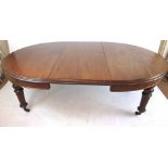 A late 19th century mahogany extendable dining table with a wind out mechanism and two leaf's on