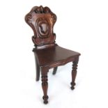 A Victorian mahogany hall chair, the carved scrolling back over shaped seat on turned front legs. h.