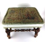 A 19th century walnut stool upholstered in a needlework of ladies under a tree above turned legs