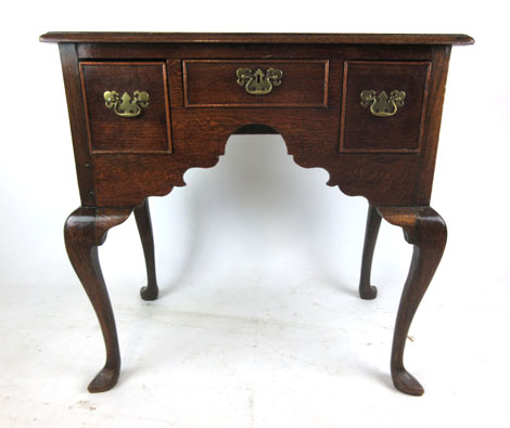 An early 18th century oak lowboy, the top over three drawers on cabriole legs, h. 74 cm, w.