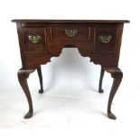 An early 18th century oak lowboy, the top over three drawers on cabriole legs, h. 74 cm, w.