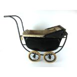 An early 20th century child's doll pram in black, with white leather interior,