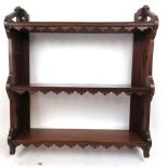 An early 20th century walnut set of wall hanging shelves with shaped and pierced sides, h. 69 cm, w.