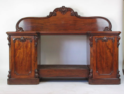 A Victorian mahogany sideboard the top over central drawer flanked by two cupboards,