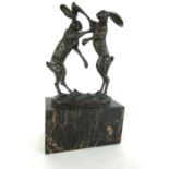 A modern bronze figure of boxing hares, signed to back 'Nick' on a black marble base, h.