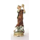 A Royal Dux figure modelled as a lady playing a tambourine on a naturalistic base, h.