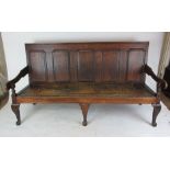 An 18th century oak settle, the five fielded panel back over animal skin seat on cabriole legs, h.